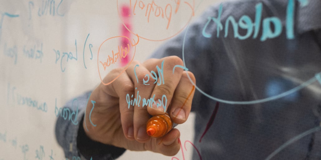 Person writing on glass wall