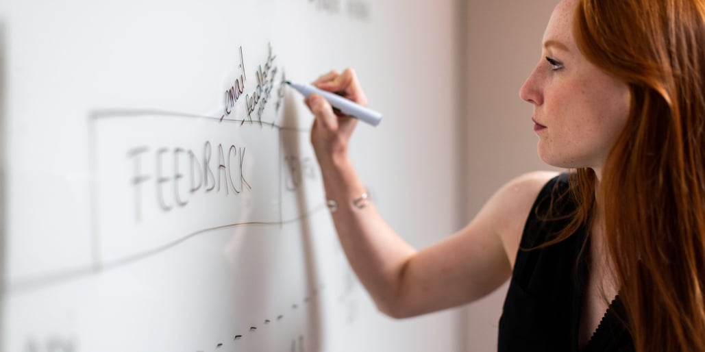 A woman writing on a whiteboard